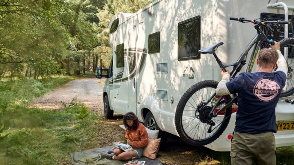 Man putting a bicycle on a camper van
